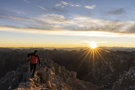 Hiker watching the sunrise from a mountain summit