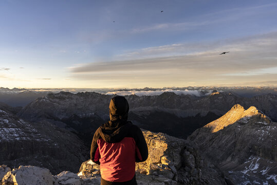 Hiker watching the sunrise from a mountain summit