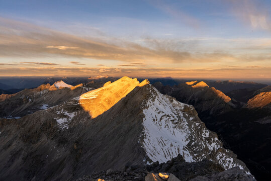Golden morning light hitting a sharp mountain peak