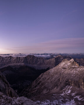 Purple twilight over a vast, snowy mountain range