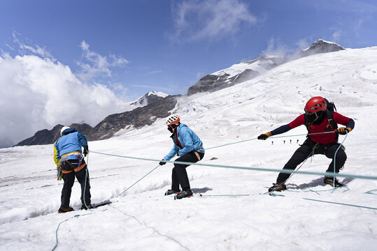 Mountaineers practicing a T-slot anchor technique for crevasse rescue