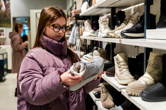 Teen Girl Choosing Winter Boots in Clothing Store