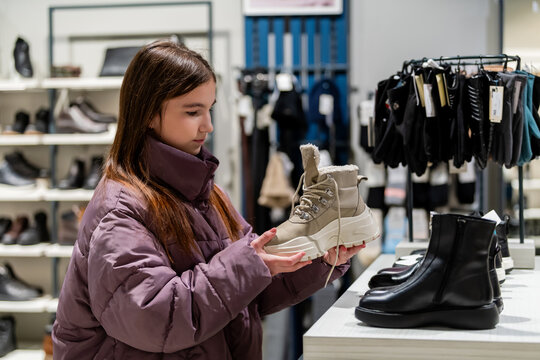 Teen Girl Choosing Winter Boots in Clothing Store