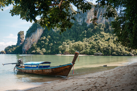 Longtail boat under tropical trees at Pak Bia Island, Krabi
