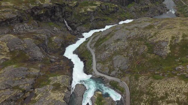 The Rallarvegen (Navvy Road) Along The Hardangervidda Plateau With Flowing Glacial Rivers In Norway. Aerial Shot