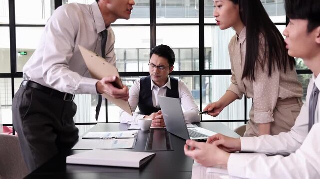Frustrated business colleagues in office environment having heated argument over documents, pointing finger and escalating tension while discussing unsatisfactory work performance at corporate meeting