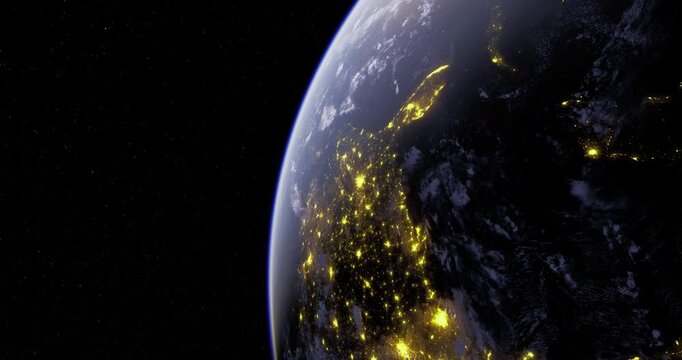 A view of the Earth at night highlights glowing cities and urban areas. The contrast of bright lights against the dark landscape showcases human habitation from a high altitude.