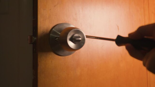 Manually securing the handle screws on the inside section of the door knob.