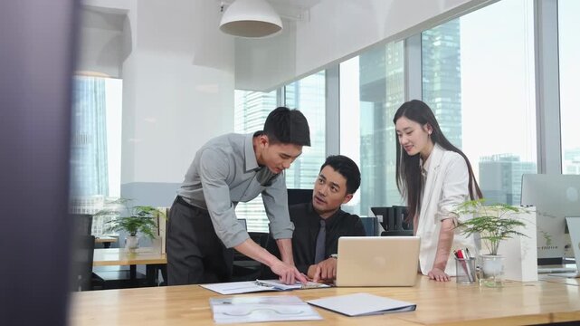 A diverse group of professional colleagues actively communicating, collaborate on new project, exchanging ideas reviewing documents at shared desk leads to innovative solutions and successful outcomes