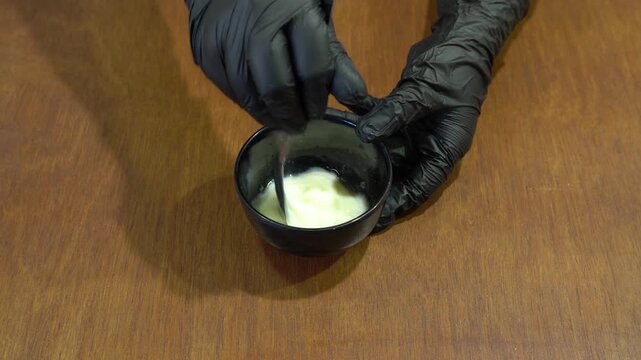 Chef With Black Gloves Stirring Sauce Creamy Liquid in Bowl Top View