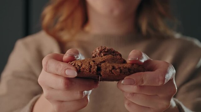 Close up of hands breaking open chocolate filled cookie