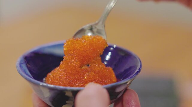 Close-up of tobiko being scooped with a spoon
