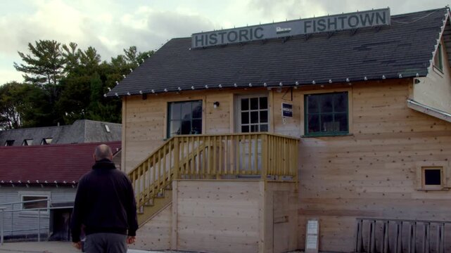 Man walking at Historic Fishtown in Leland, Michigan with stable video shot.