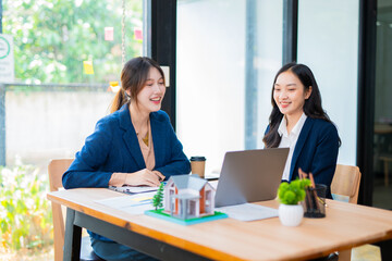 Obraz premium Two businesswomen are considering documents in an office.