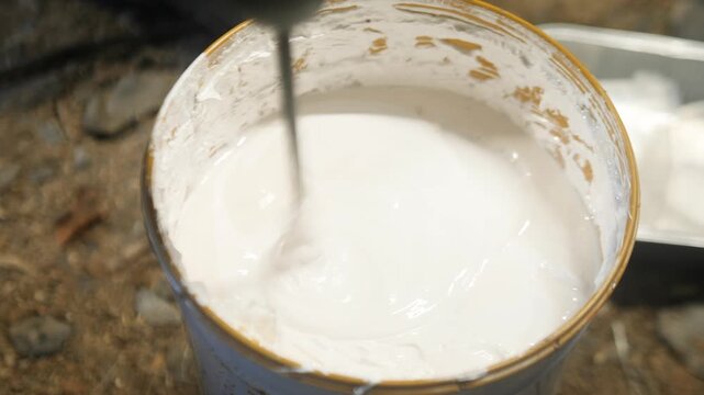 Mixing, stirring paint in tin using drill attachment