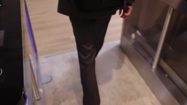 Businessman in a suit pass over in coworking space. Enter the business center indoors. holding electronic entrance gate card. Turnstile with touch panel for automatic scanning identification in office