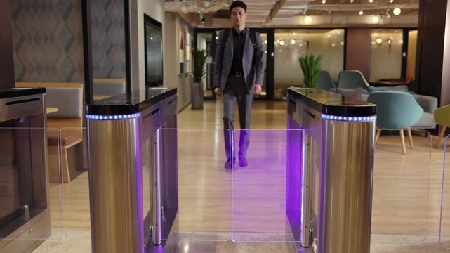 Businesspeople in a suit carrying a backpack walks out of the turnstile, employees leaving workplace finish workday with touch panel for automatic scanning and identification in modern office building