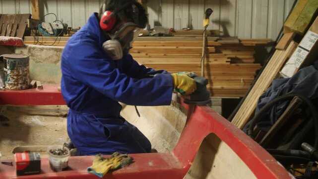 Sanding fiberglass gunwale repair on small fishing boat