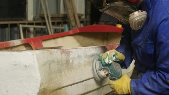 Sanding glass fiber boat hull using orbital sander