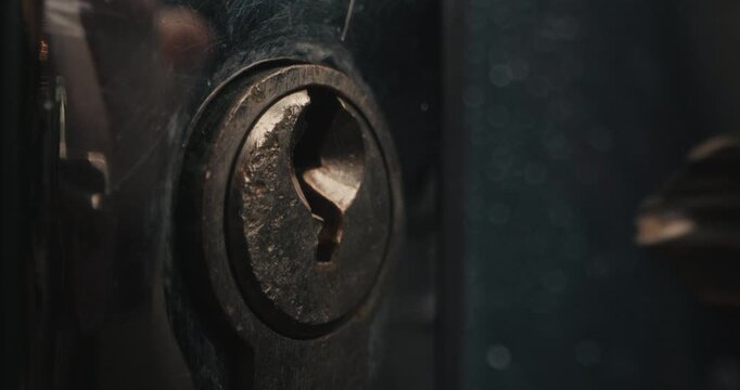 A detailed view of a key being inserted and turned in a lock. The focus is on the mechanism and movement.