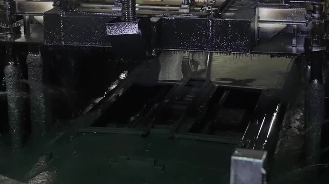 Industrial lift mechanism raising a metal bus frame from a specialized chemical coating bath