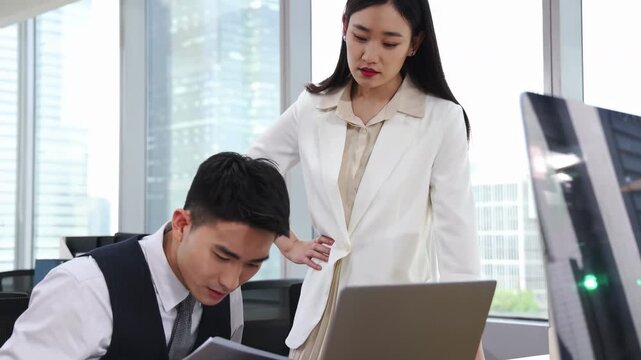 Business woman manager leader, is furiously shouting, scolding, anger standing face to face with a employee deeply bowing her head in apology with serious expression in modern office by glass window
