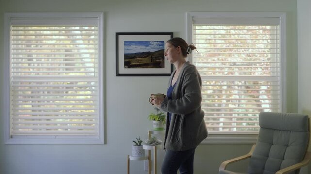 A woman walks outside from her living room into a sunny fall day.