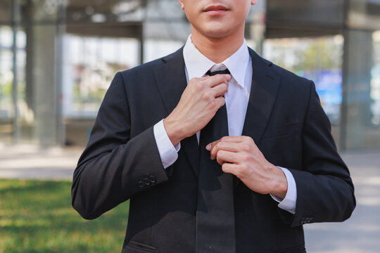 Business man adjusting tie getting ready for work