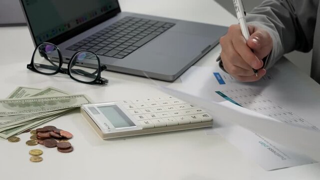 Businessman accountant working with finances paperwork to analyze cost calculator about financial reports, next one hundred dollar bills, stack golden coin. Concept of saving money, financial planning