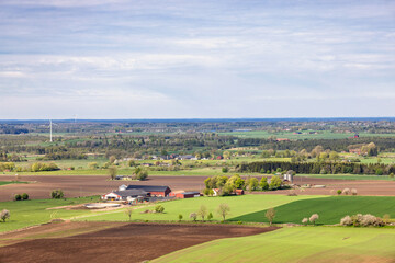 Fototapeta premium Scenic view at a countryside with farms and green fields a beautiful sunny spring day