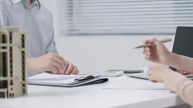 Clients signing mortgage agreement in bank office, mortgage property insurance. New home, successful deal meeting. Businesspeople choose right real estate agency to buy home suiting preferences.