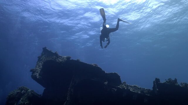 A scuba diver glides along the exterior of the tilted Giannis D shipwreck at Sha'ab Abu Nuhas reef in the northern Red Sea off Egypt.