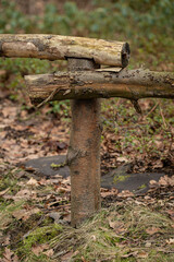 Fototapeta premium A close-up of a wooden post and logs used as a railing — old and decaying.