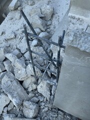 Demolished concrete structures with exposed steel rebar and rubble at a construction site, debris from building renovation or demolition work.