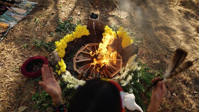Hands lifted toward ceremonial fire during traditional Mayan ritual in Guatemala