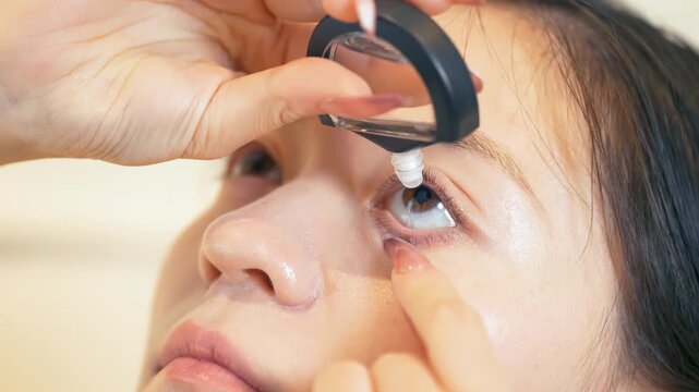 Young woman applying eye drops in dry irritated eyes after long working day with computer in office. Lady using eyedrops antihistamine ophthalmic antibiotic medication for infection treatment concept
