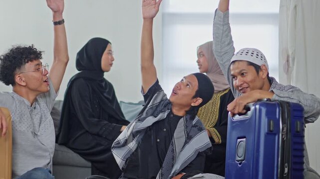 Young Indonesian Muslims cheering and putting hands together while preparing for Mudik holiday travel