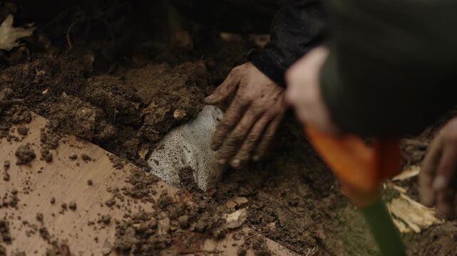 People Burying Person With Head Covered In Sack In The Pit. - closeup shot