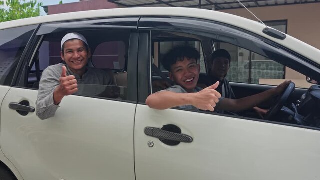 Three happy Indonesian men giving thumbs up from car window ready for Mudik homecoming