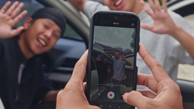 POV of recording vlog with friends near vehicle during eid homecoming
