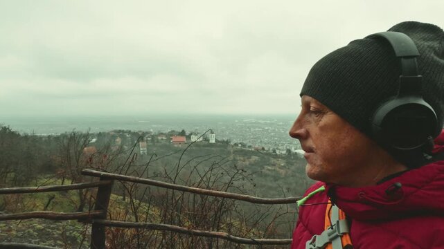 Determined 50 year old male athlete navigating foggy winter woods in rain for cardio, stamina and health.