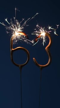 63 years celebration festive background made with Bengal fires in the form of number Sixty three. Vertical footage.