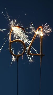 64 years celebration festive background made with Bengal fires in the form of number Sixty four. Vertical footage.