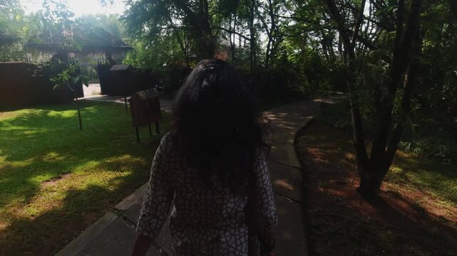 Indian Woman casually walking inside a luxury, eco-conscious, forest resort in Nagarahole, Karnataka, India