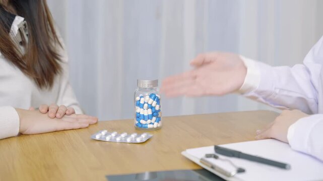 Caring therapist doctor explaining treatment using pill and advice to patient instructions drug usage guide after check treatment, recommended and prescribed medications in medical room at hospital.