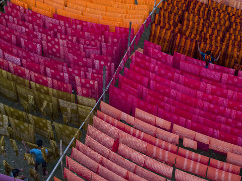 Narayanganj, Bangladesh - 08 March 2026: Aerial view of vibrant textiles drying in the sun, their patterns and colors creating a rich tapestry of textures and tones.