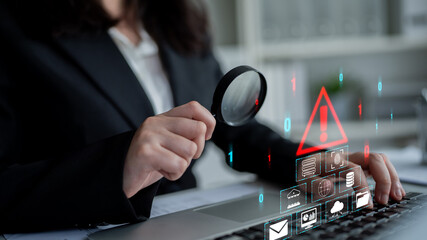 Business professional analyzing cybersecurity threats with magnifying glass and digital icons...