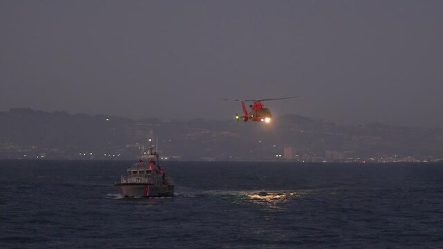Coast Guard Rescue Helicopter Flying Over Ocean with Boat