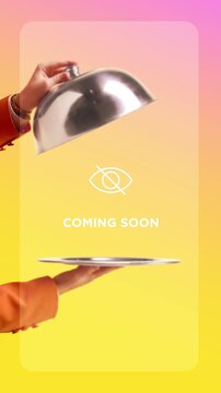 Hand lifting metal cloche above empty plate on colorful gradient background with coming soon message. Concept of product launch, anticipation, teaser campaign and marketing promotion.