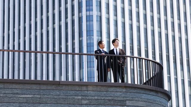 Business people have conversation with meeting outdoor for planning or discussion project on modern rooftop terrace, building real estate with client, developer for commercial investment on balcony